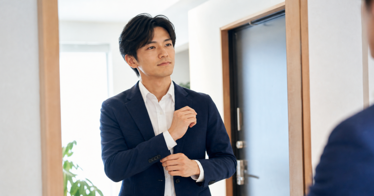 ネイビージャケットと白シャツで婚活の身支度を整える男性の写真