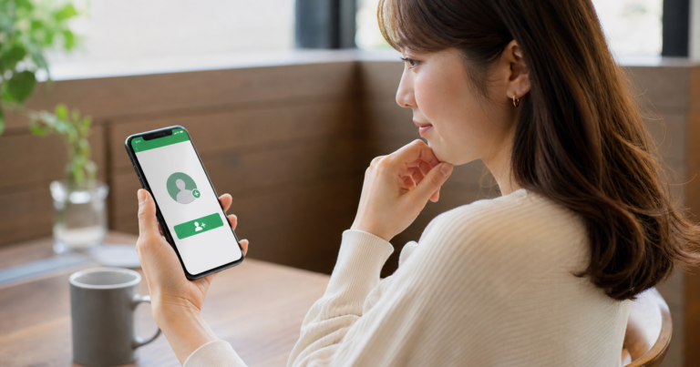 マッチングアプリでLINE交換について考え込むスマートフォンを持つ女性の写真