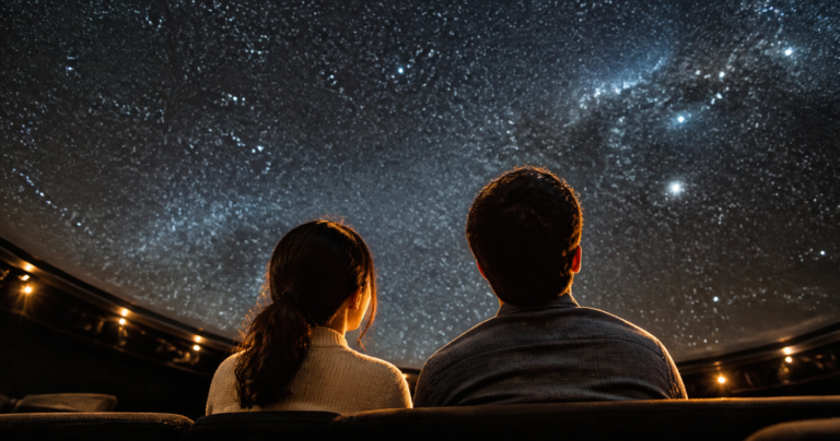大阪市立科学館のプラネタリウムで並んで星空を見上げるカップルの後ろ姿