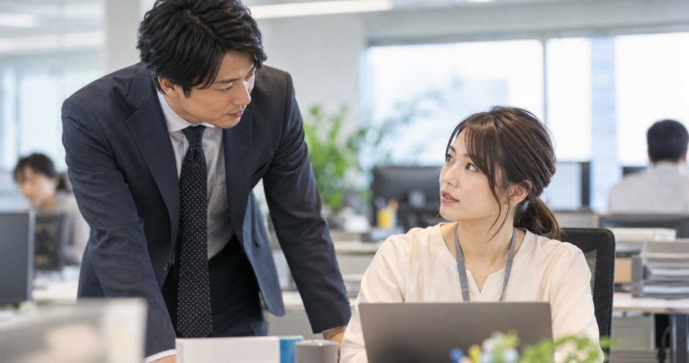 職場で心配そうに声をかける男性社員の写真