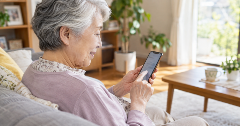 スマホでマッチングアプリの画面を確認する70代くらいの男女の写真