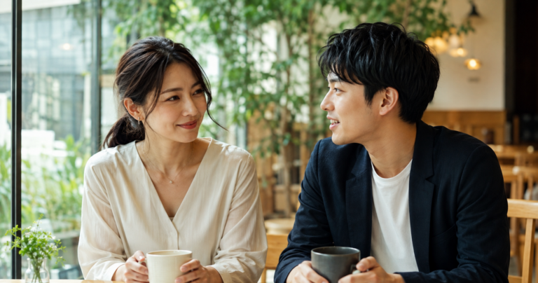 オフィスで笑顔で話す年上女性と年下男性の写真