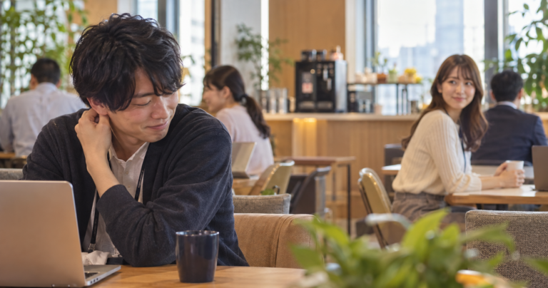 恥ずかしそうにスマホを操作する内気な男性の写真