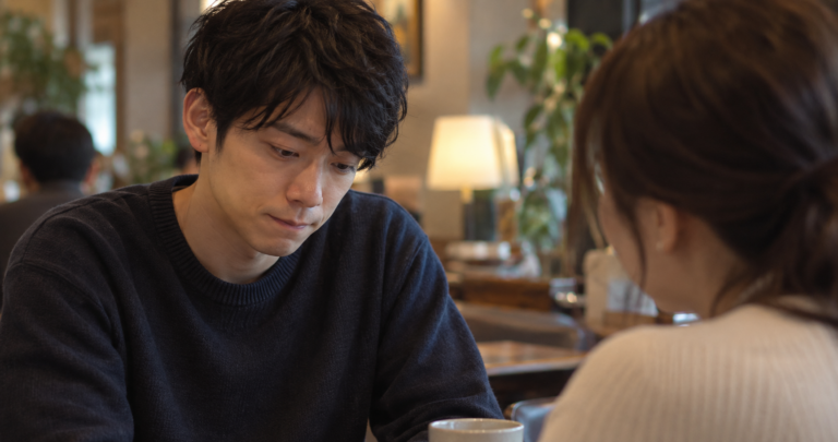 うつむいて言葉に詰まっている様子の男性の写真